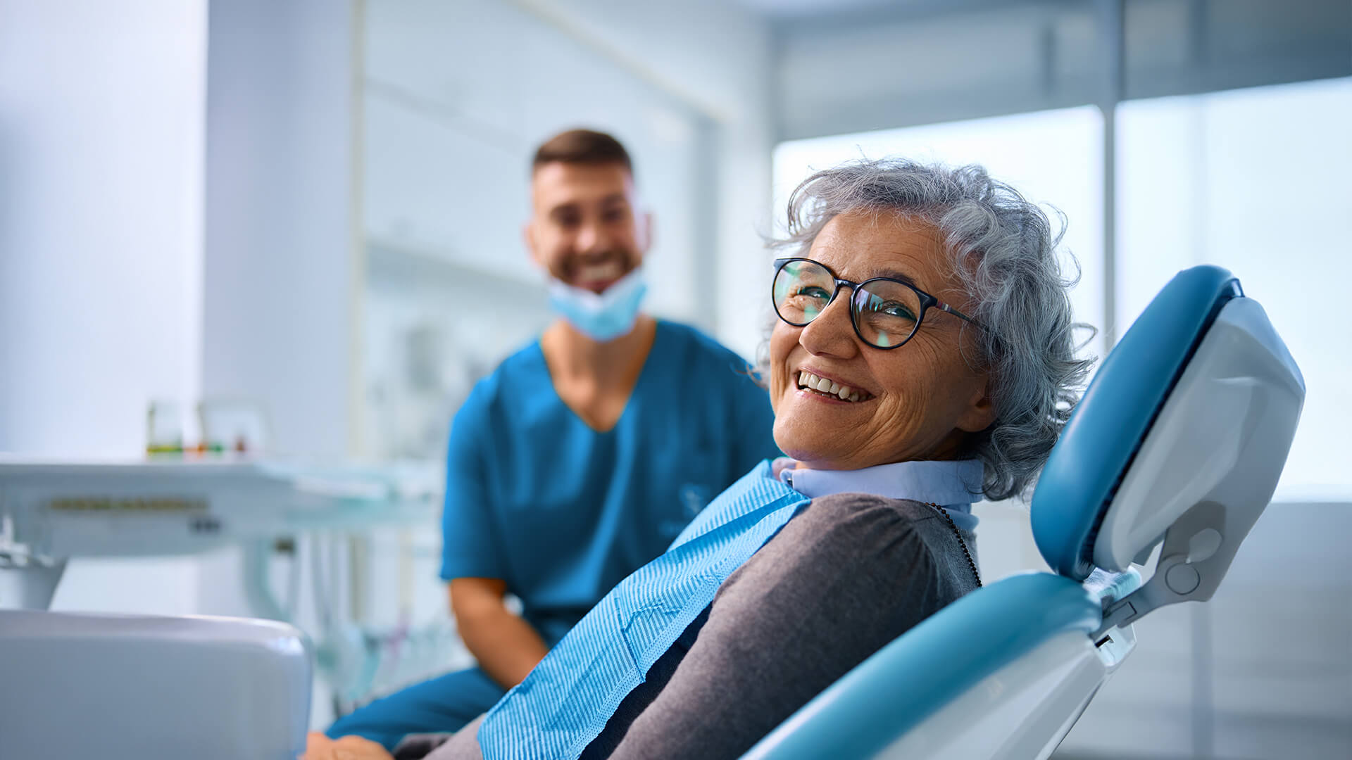 Foto di un dentista che spiega a una paziente quali sono i sintomi della parodontite