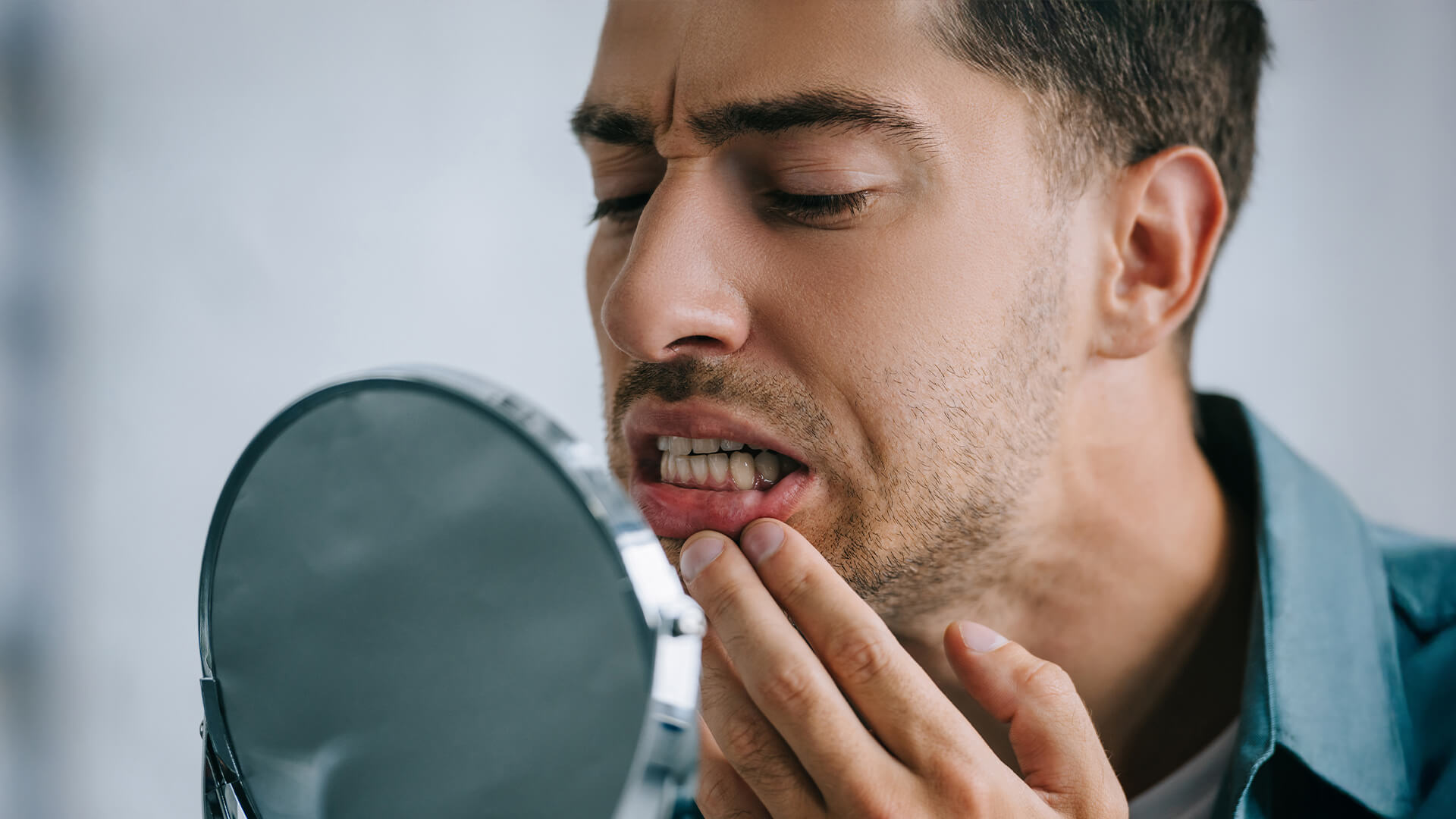 Foto di una persona che si controlla le gengive per capire se sanguinano