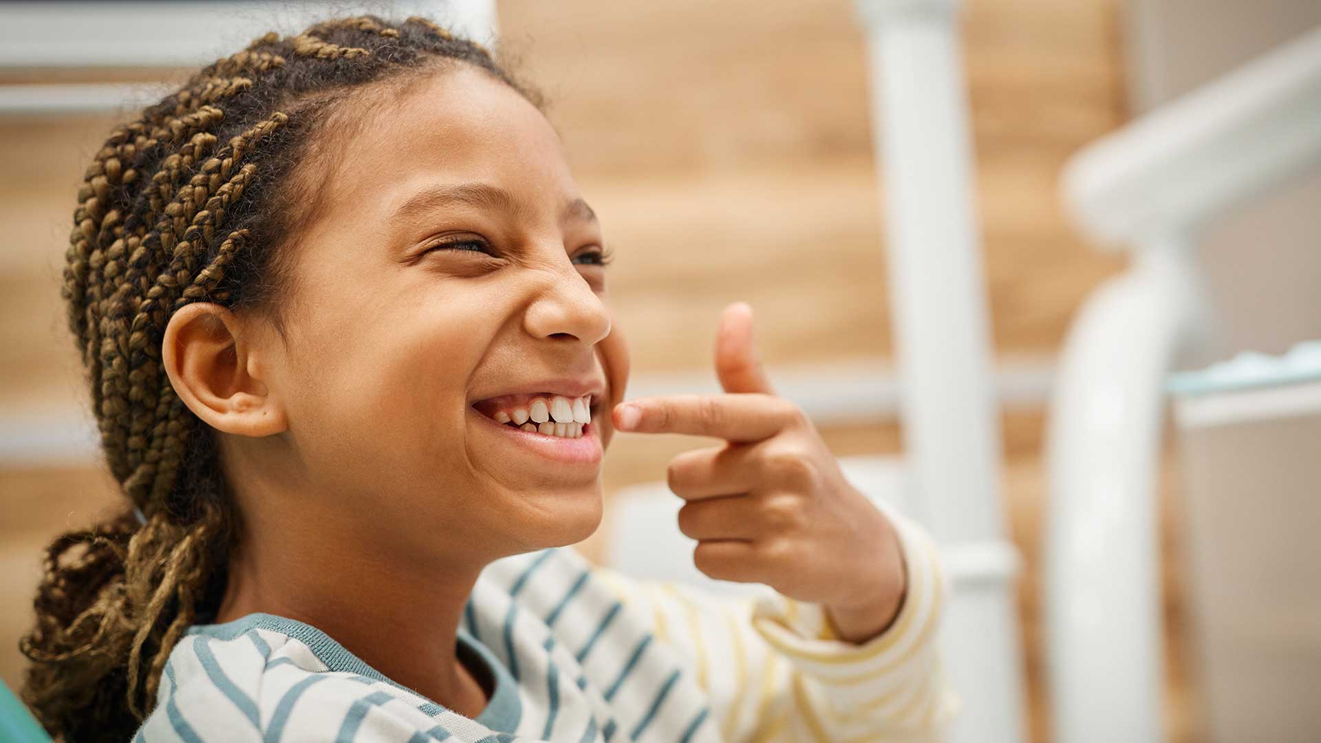 Foto di una bambina che si indica gli incisivi perché soffre di MIH
