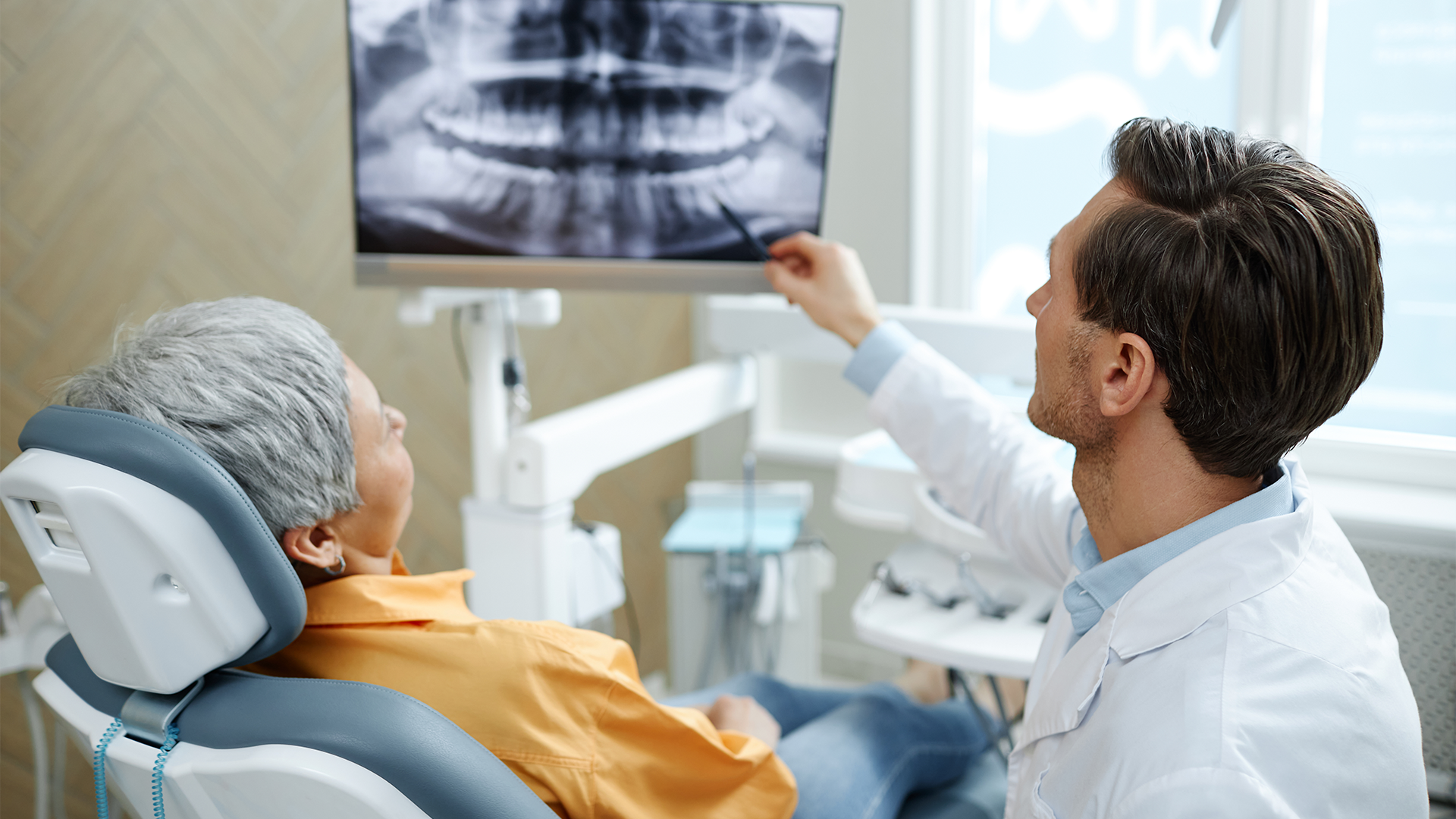 Foto di un odontoiatra che spiega al paziente il trattamento della perimplantite